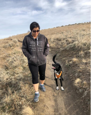 trainer walking in the foothills withi her dog